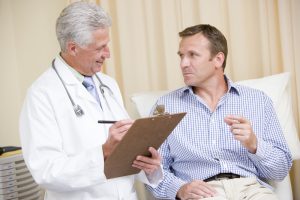 Middle-aged man having a follow-up with his provider while recovering from his vasectomy.