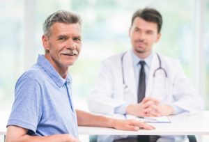 Older man sitting down with his doctor to discuss testosterone replacement therapy for renewed energy and well-being.