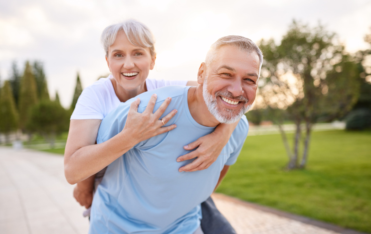 Portrait of lovely happy elderly couple on morning run outside in city park Older couple smiling and happy together after getting treatment for sexual health, wellness, and aesthetics.